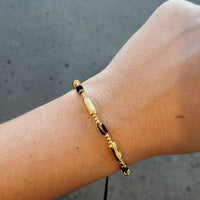 Gold bracelets with black adjustable cord
